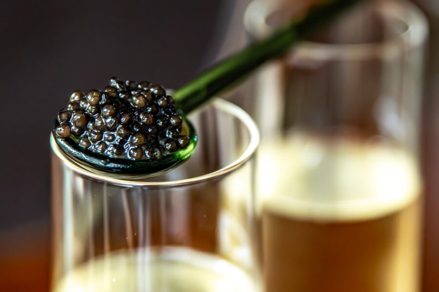 A spoon of caviar on a glass of Champagne at the bar