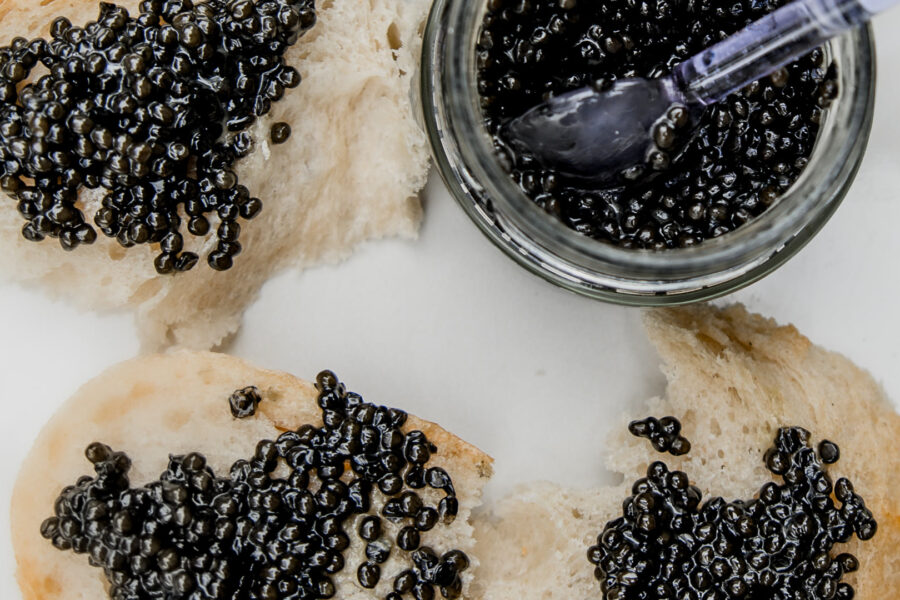 Caviar on toasted bread beside an open jar