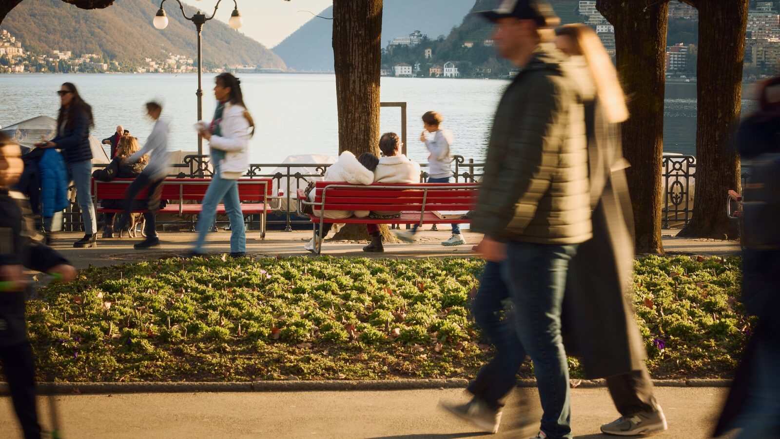 People strolling along the lakeside promenade in Lugano on a spring day