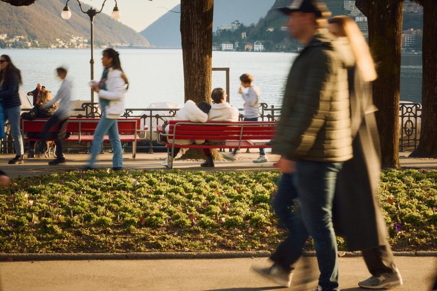 People strolling along the lakeside promenade in Lugano on a spring day